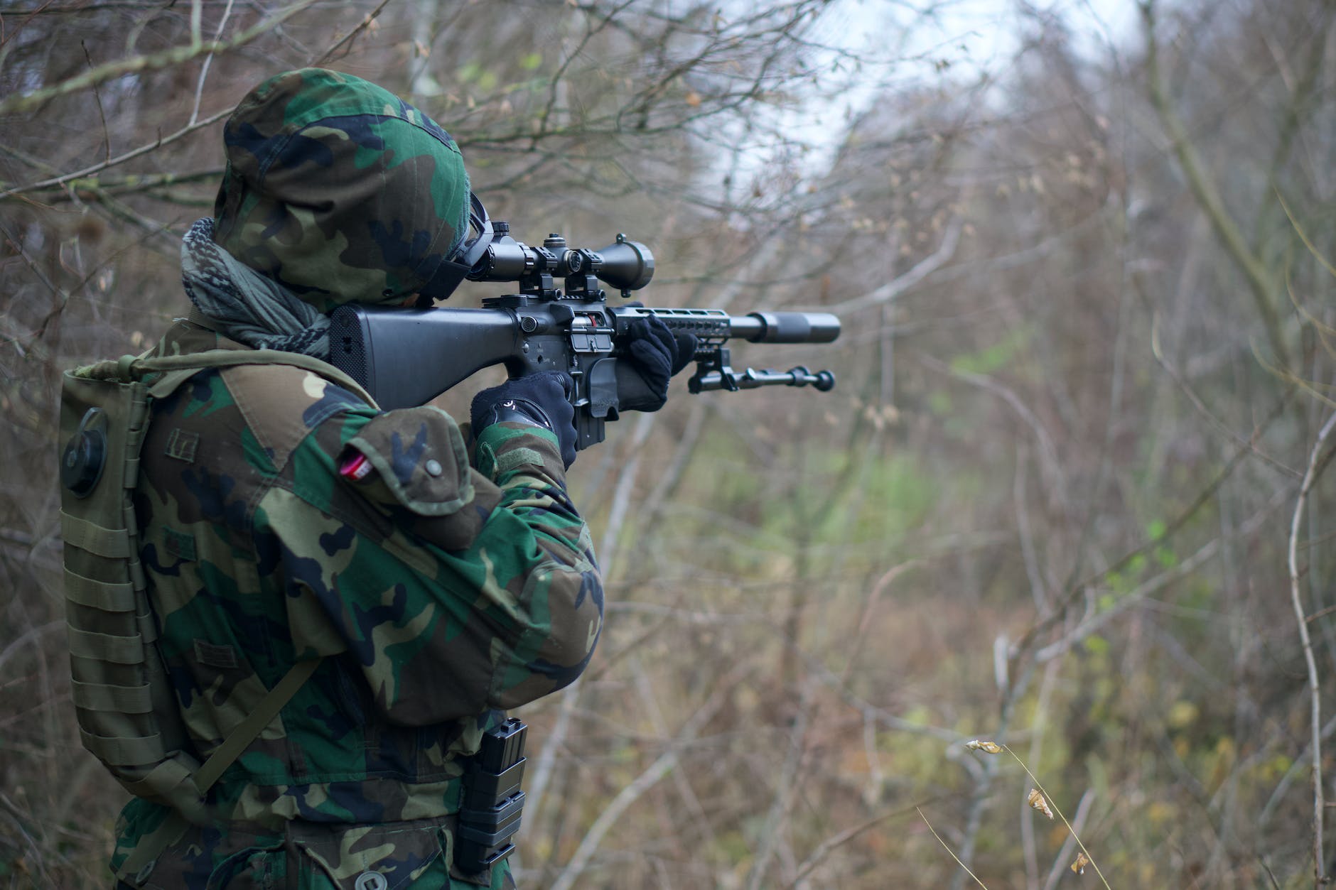 man in camouflage army uniform holding rifle